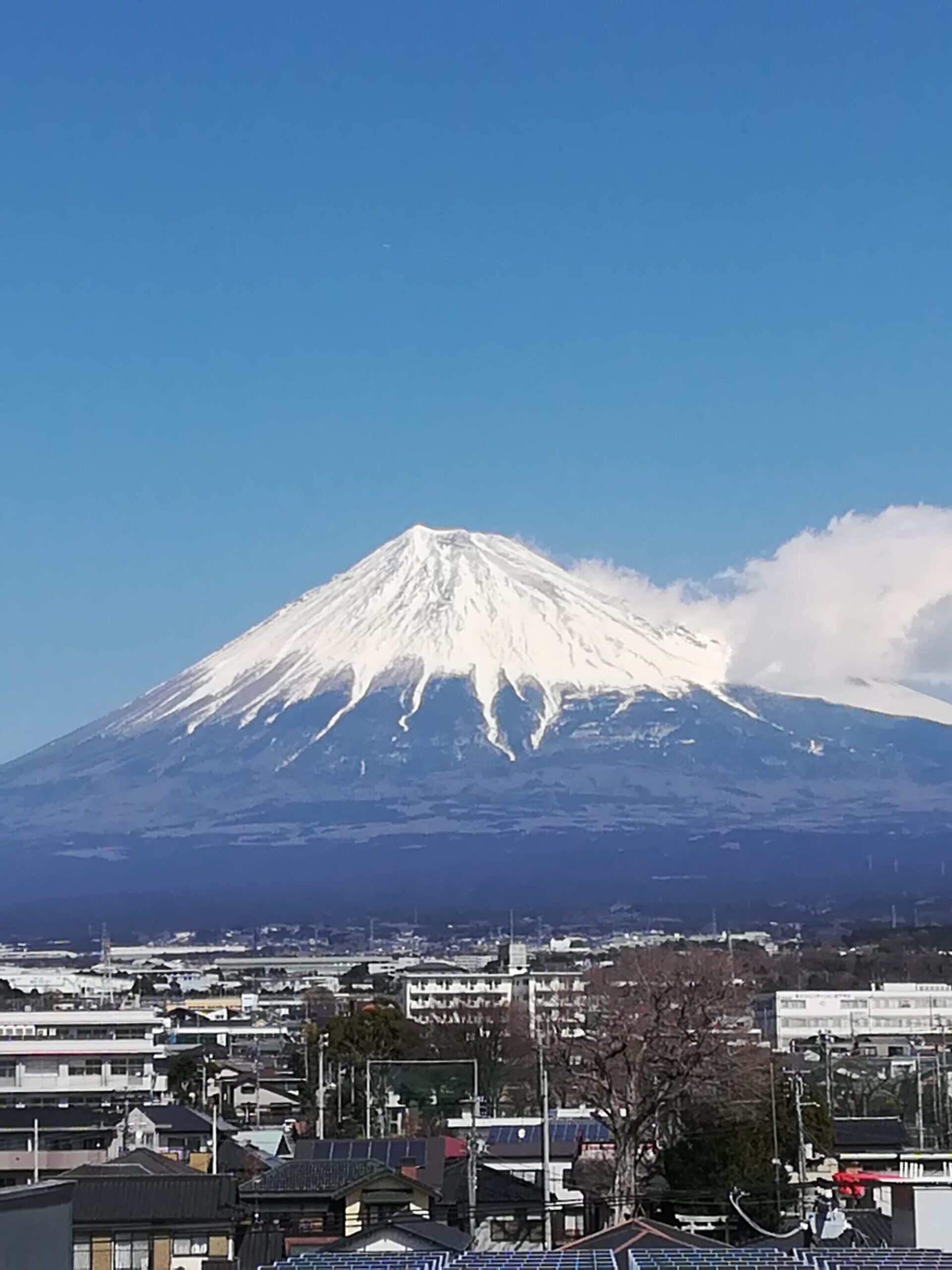 雪をいただいた富士山と、そのふもとの街並み